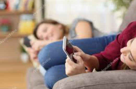 Young people in a modern apartment sitting and using their cell phones
